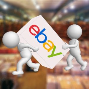 Imagen de dos monigotes levantando una caja con el símbolo de eBay