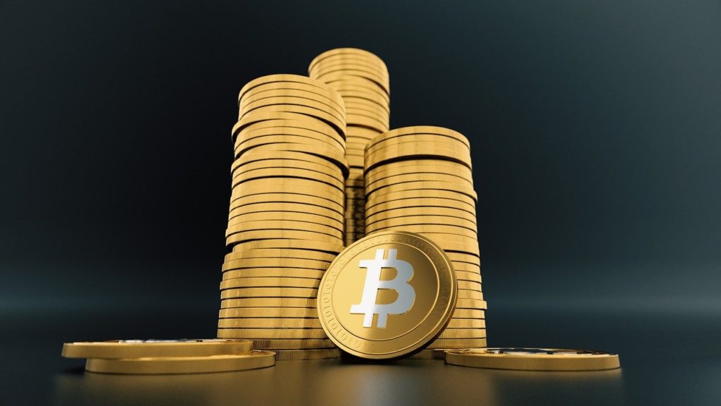 Imagen de tres montones de criptomonedas con el símbolo de Bitcoin